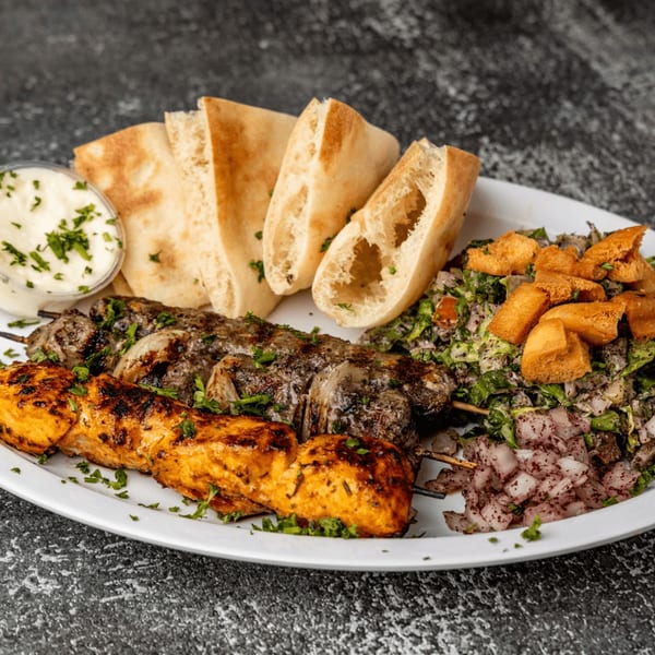Shawarma Zone's grilled chicken and beef skewers with pita bread, salad, and dipping sauce.