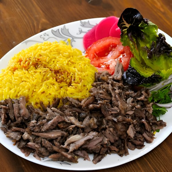 Shawarma Zone's beef shawarma plate with yellow rice, pickled turnips, tomatoes, and lettuce.