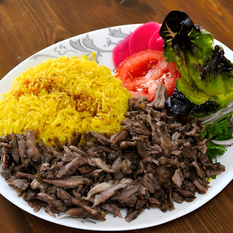 Shawarma Zone's beef shawarma plate with yellow rice, pickled turnips, tomatoes, and lettuce.